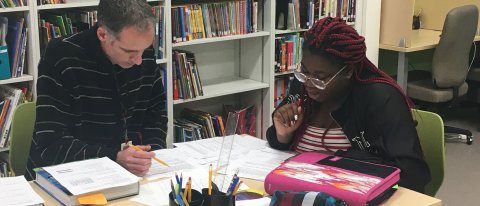 Teacher Marty Hoehn reviews math problems with a patient